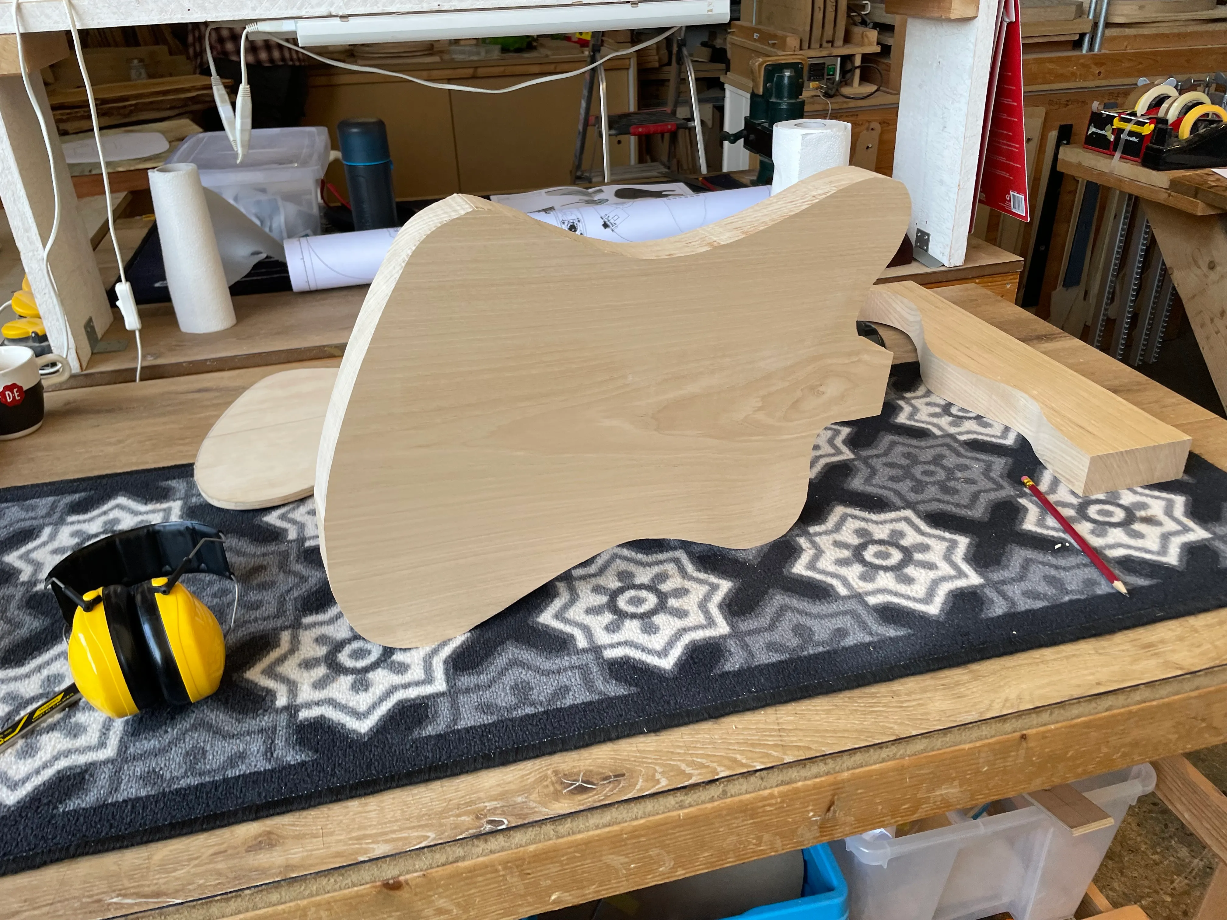 The rough cut guitar body standing on it’s bottom edge on my bench. The shape is a sort of hybrid jazzmaster and reverse firebird.