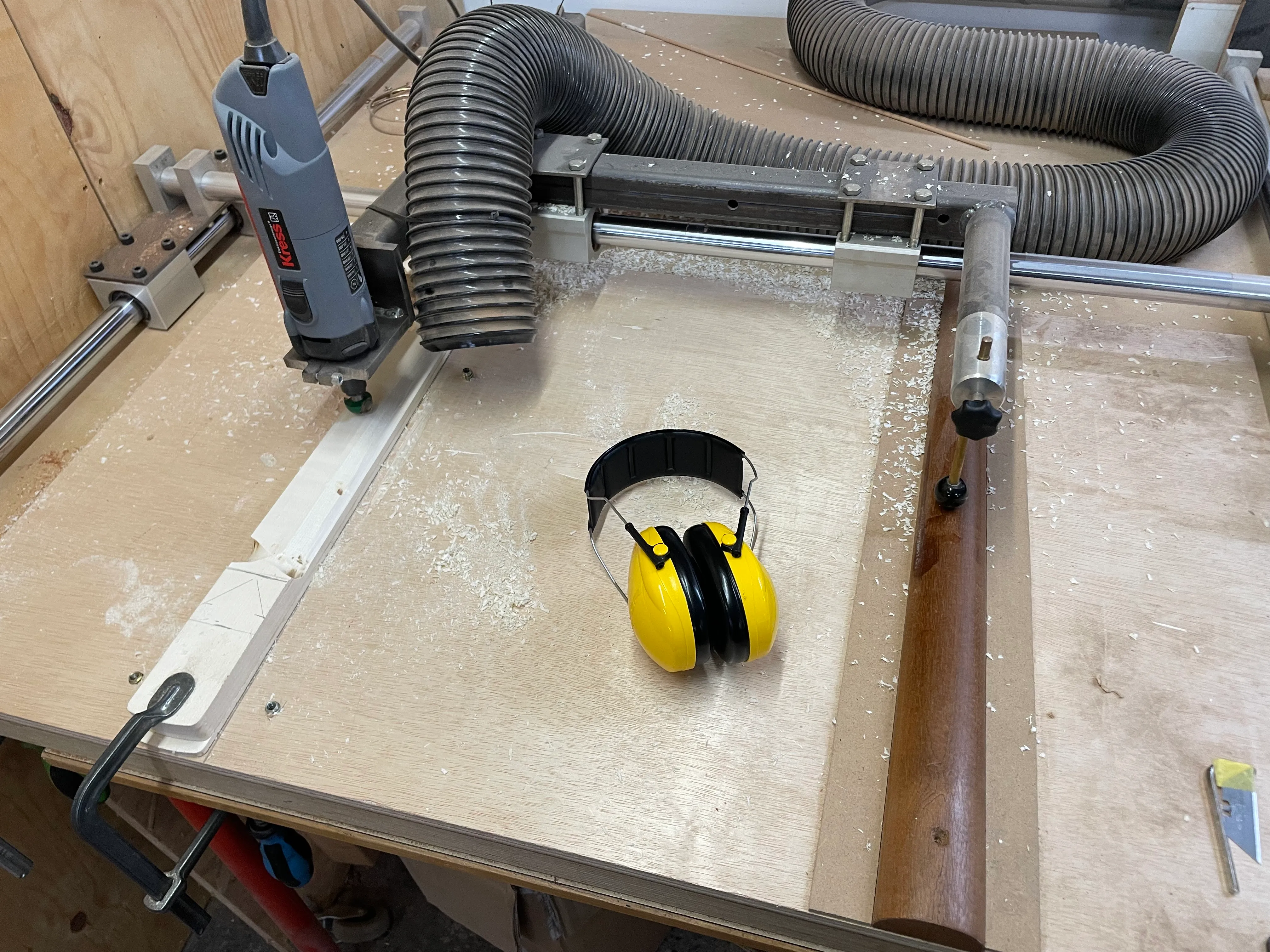 Routing the round part of the neck using a router strapped to a gantry that follows a preshaped neck, which I guess strictly speaking is a conical section. A ball end restricts the movement of the router so that you can’t carve too much away. Only 3 hours or so left in week one, we’re nearing the halfway point!