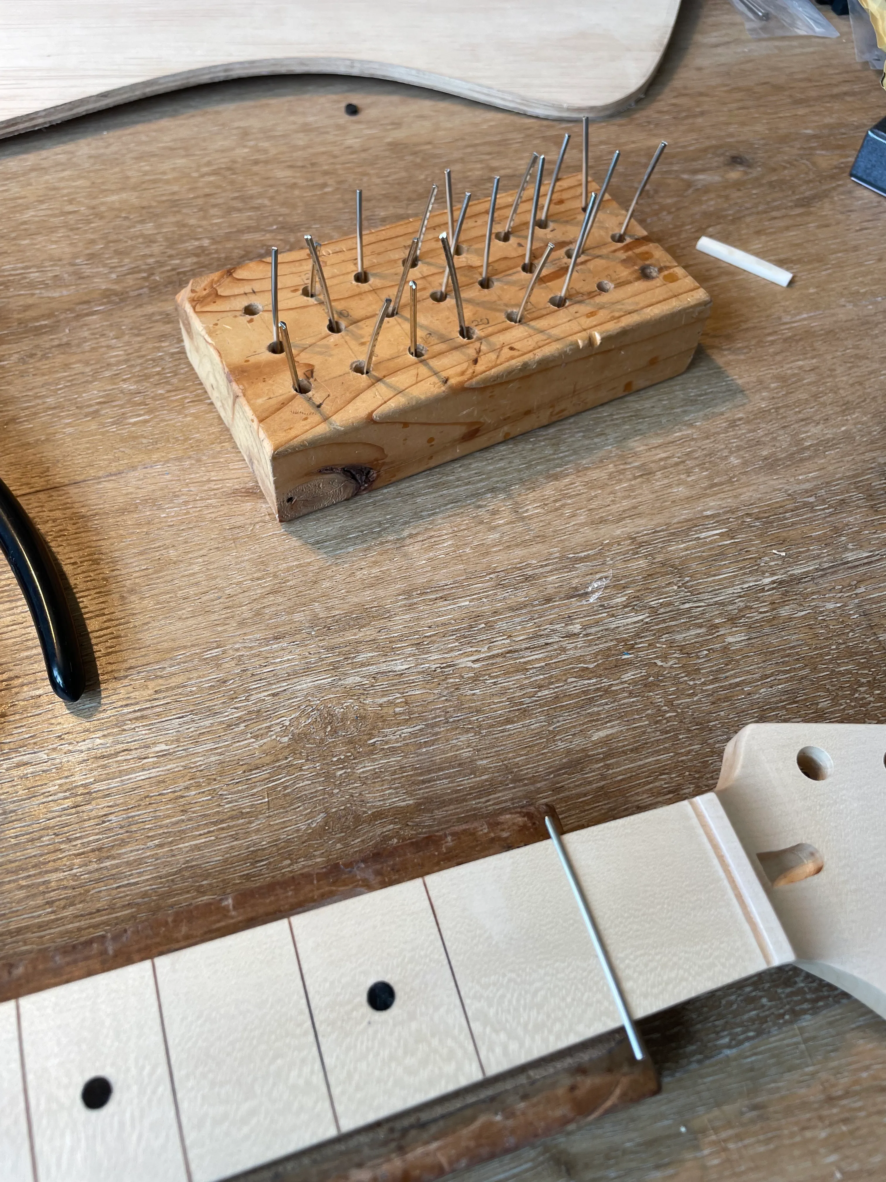 I filled a block of holes with frets cut to length. Now hammering them into place.