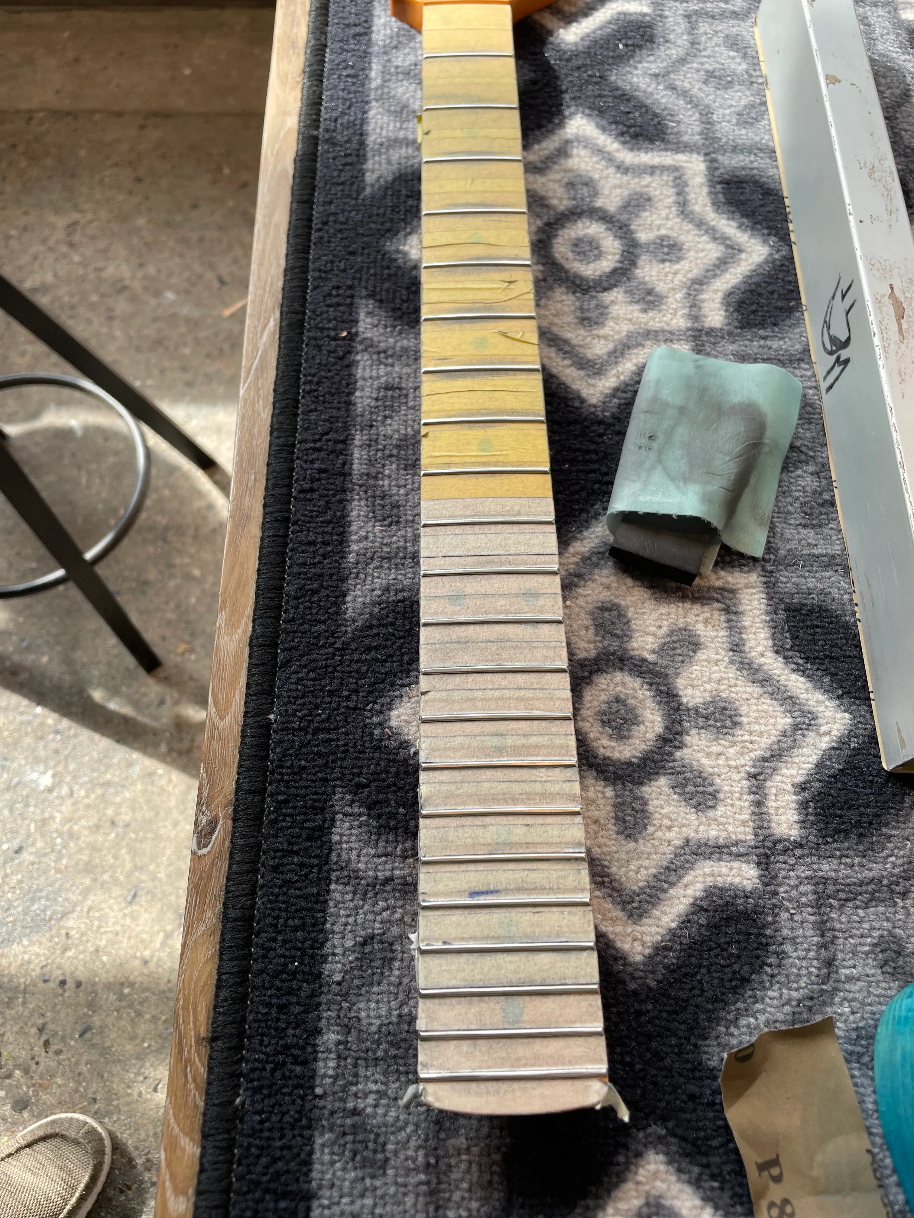 I taped off the frets on my fretboard, leveled and crowned them. Not my favorite process so far - but not as bad as copper lining the cavities!